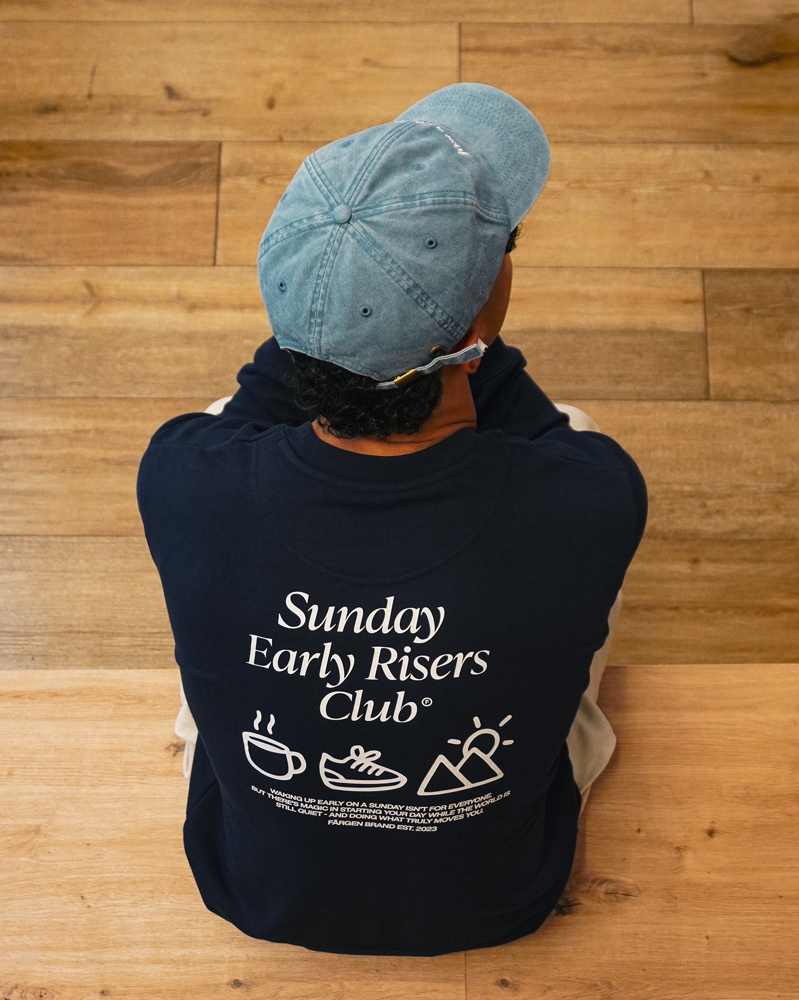 Sudadera Färgen Sunday Early Risers Club en exterior, estilo casual-outdoor para mañanas frescas en cafetería minimalista.