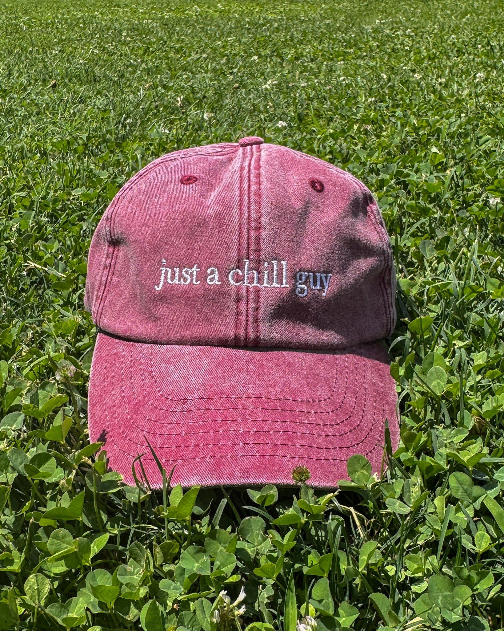 “Detalle del parche Just a Chill Guy en gorra Färgen, estética minimalista en cesped natural.