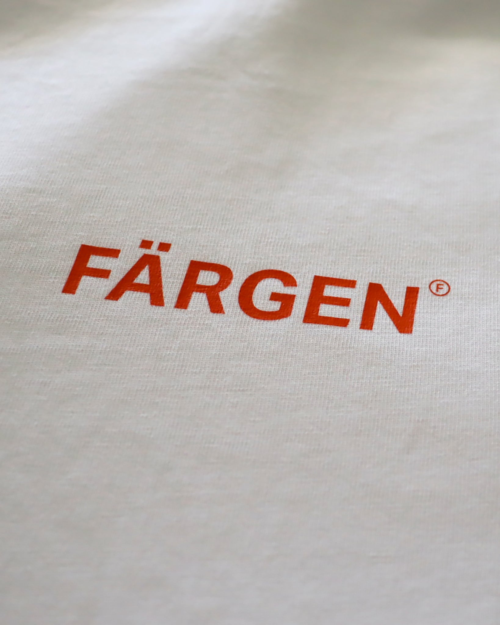 Detalle del logotipo Färgen en naranja estampado en el pecho de la camiseta Il Caffè di Casa.