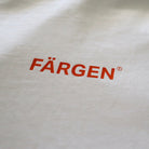 Detalle del logotipo Färgen en naranja estampado en el pecho de la camiseta Il Caffè di Casa.