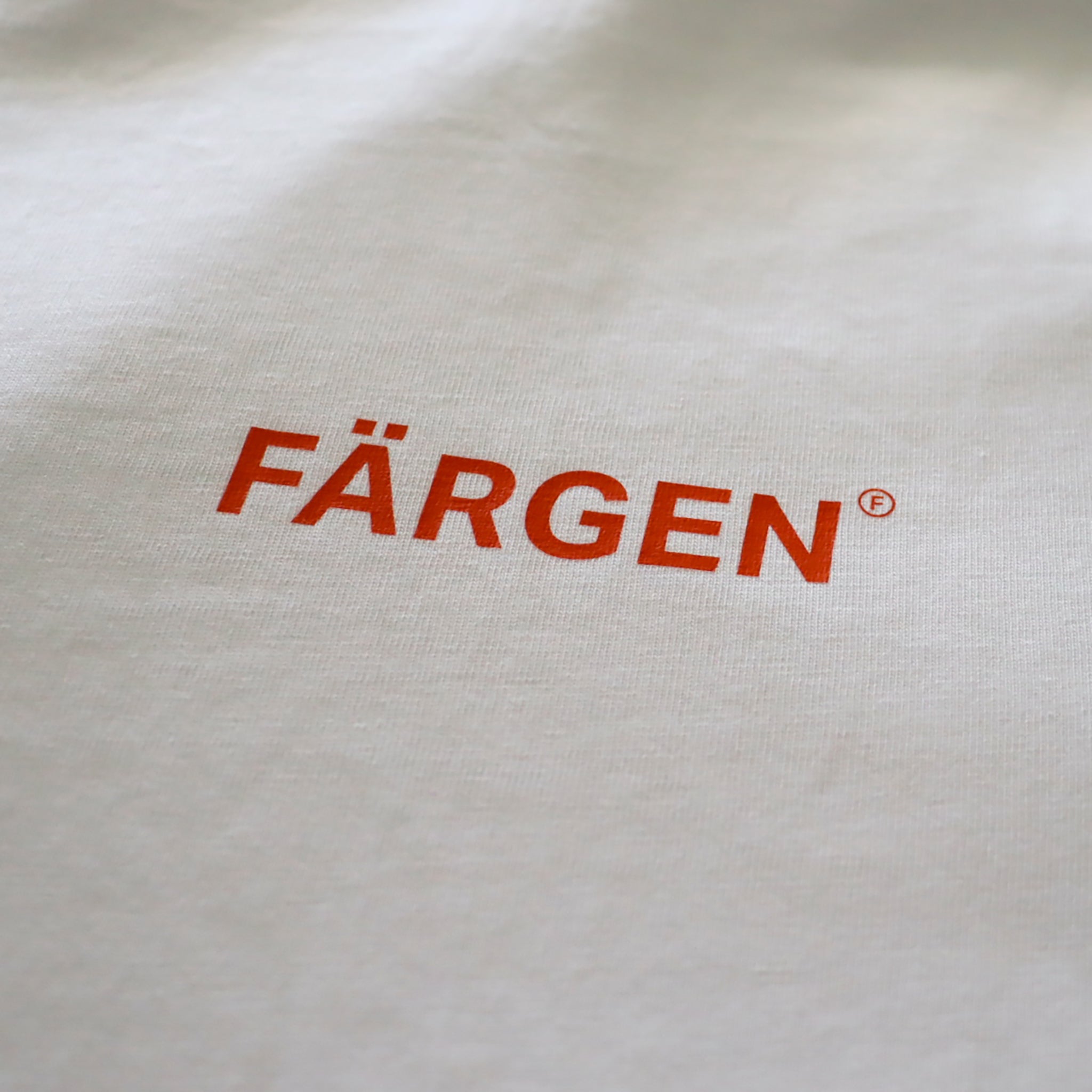 Detalle del logotipo Färgen en naranja estampado en el pecho de la camiseta Il Caffè di Casa.