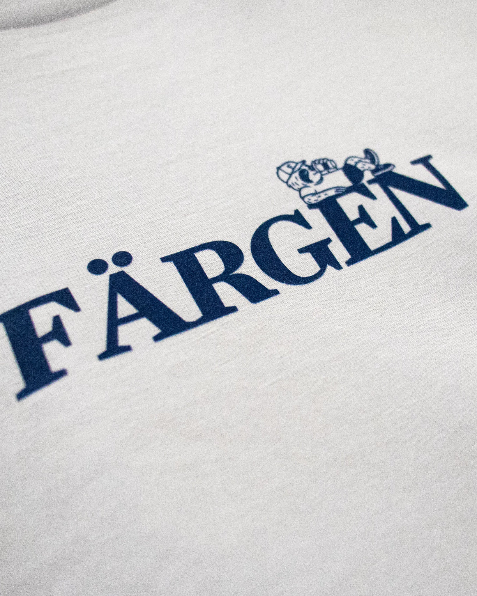 Detalle del logotipo Färgen en azul con personaje del perezoso sobre las letras.