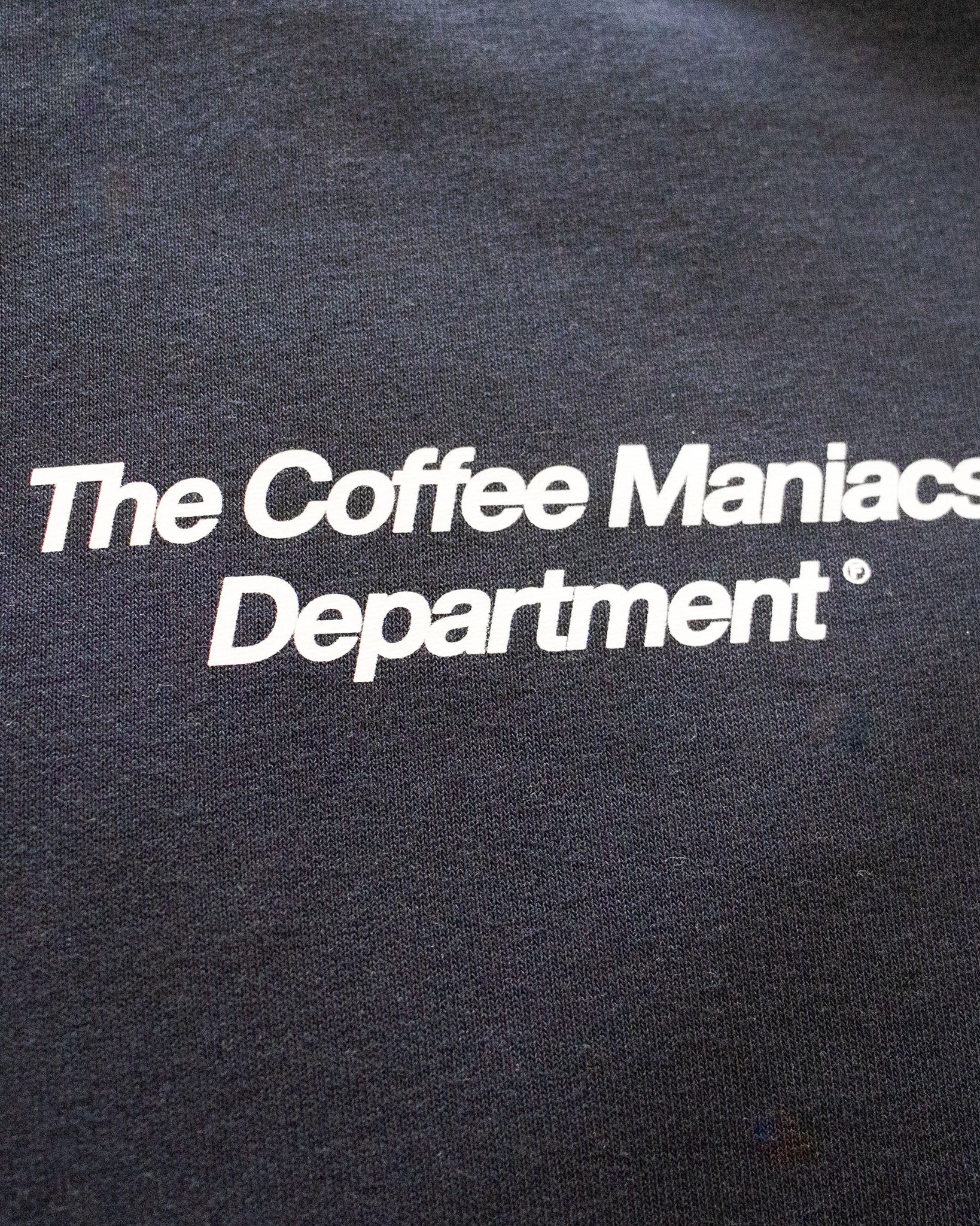 Detalle del texto The Coffee Maniacs Department en el pecho de la sudadera azul marino Färgen.
